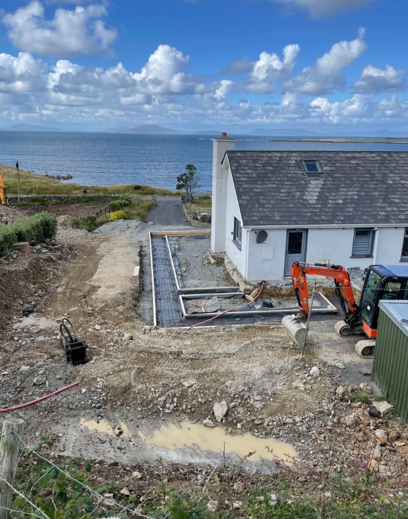 Excavator work during perimeter set-out at coastal site
