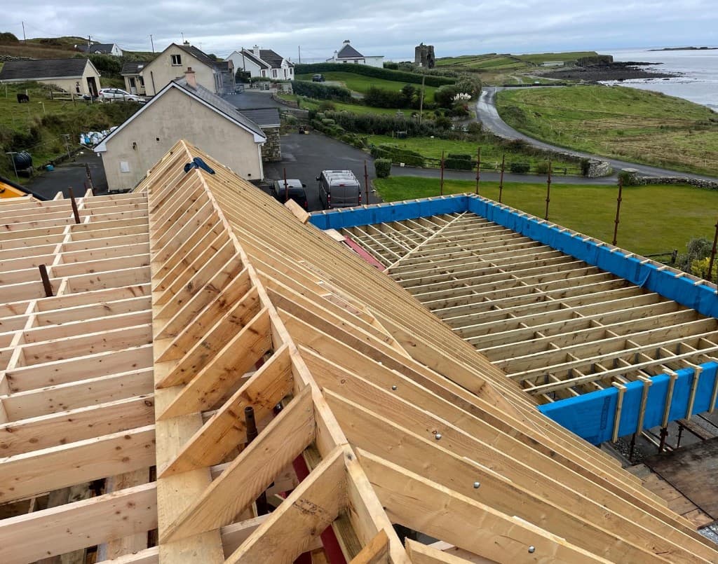 Mid-build structure stage — new roof framing and extension zone