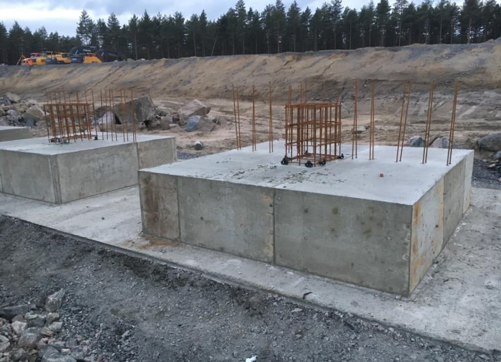 Cast concrete pads and starter bars for vertical structure